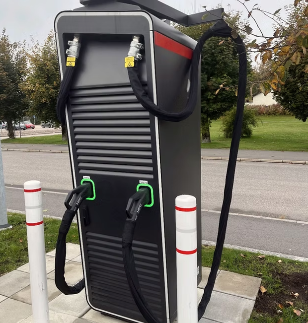 Von POWERbuilder bereitgestellte Originalaufnahme einer DC-Ladestation mit Schutzummantelungen an beiden Kabeln.